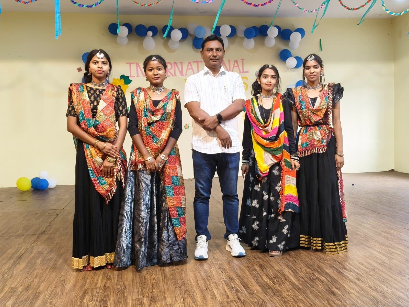 Students in traditional dress at a cultural programme with faculty