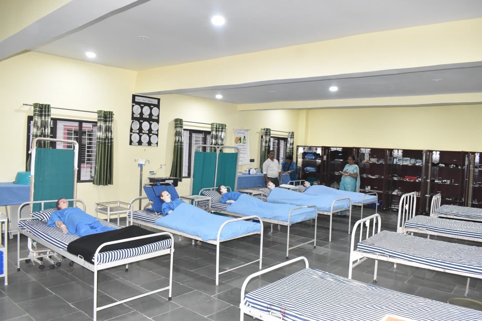 Nursing practice ward with bedside screens, supply cabinets and teaching displays